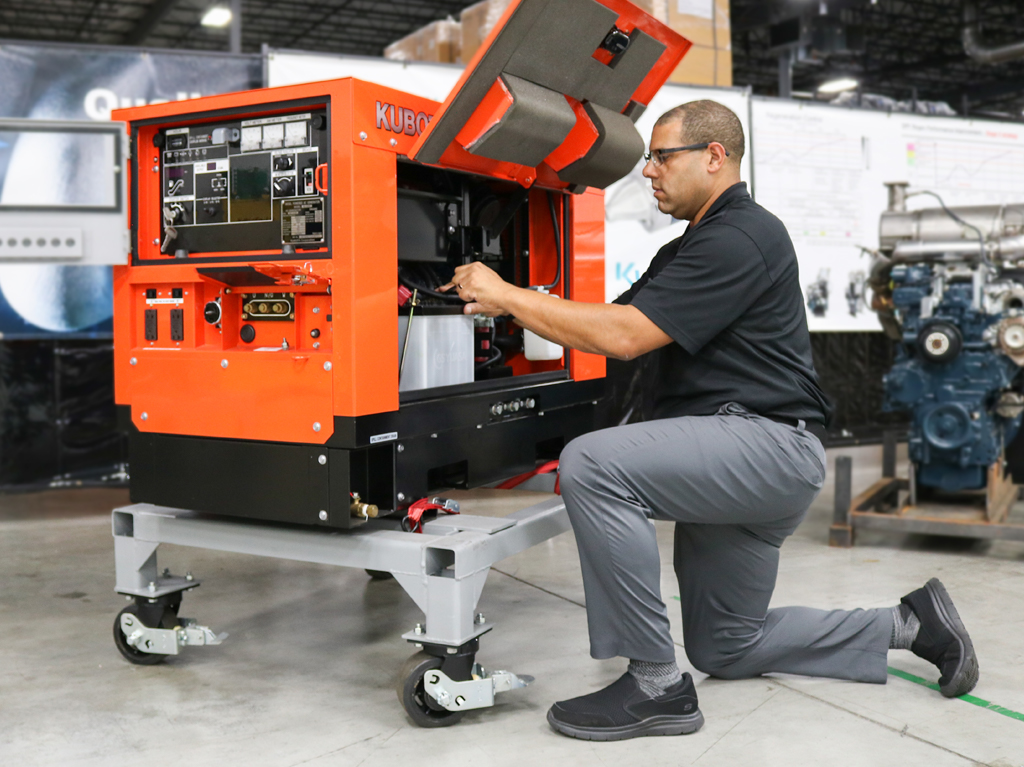 man kneeling to work on the inside of a Kubota generator
