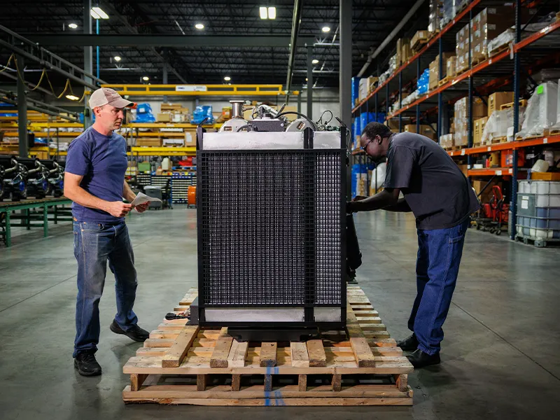 Kubota engine distributor technicians preparing industrial engine equipment in a warehouse facility