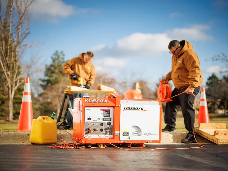 Construction employees using a Kubota Lowboy II generator on a jobsite to power their tools.